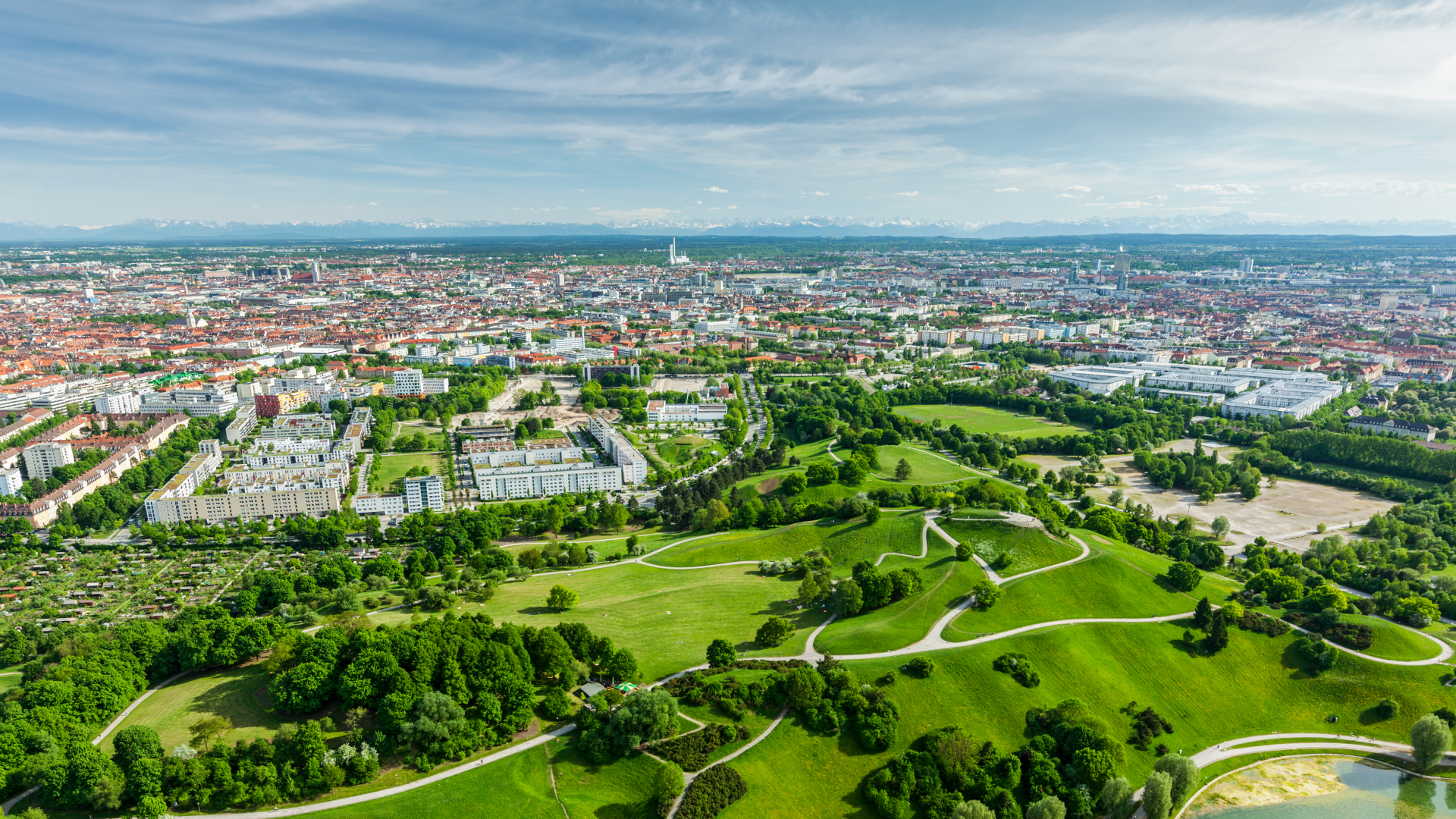 Landschaft mit grüner Wiese und Stadt im Hintergrund