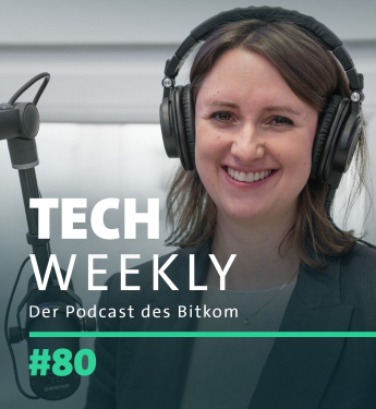 Bitkom-Politik-Expertin Sophie Vogt-Hohenlinde mit schulterlangem braunem Haar steht im Podcast-Studio und lächelt in die Kamera. Sie trägt große schwarze Over-Ear-Kopfhörer und ein dunkelgraues Blazer-Jackett über einem grauen Oberteil. Vor ihr steht ein professionelles Mikrofon mit schwarzem Schwenkarm. Der Hintergrund ist ein neutraler, heller Raum mit einer geschlossenen Tür. Überlagert auf dem Bild steht der Titel des Podcasts: „TECH WEEKLY – Der Podcast des Bitkom“, sowie die Episodennummer „#80“.